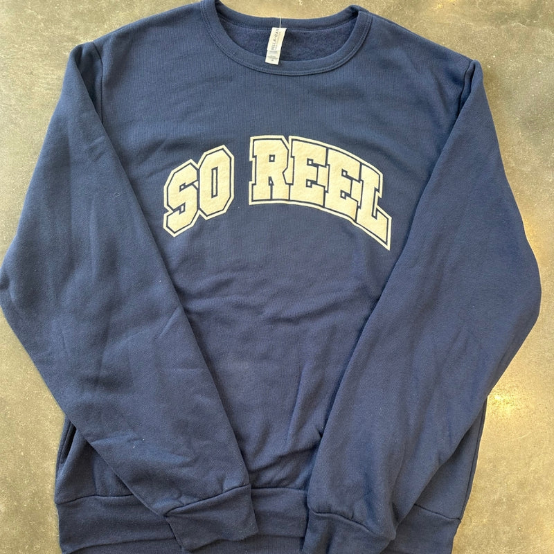 Load image into Gallery viewer, Blue sweatshirt with 'SO REEL' text on a beige surface